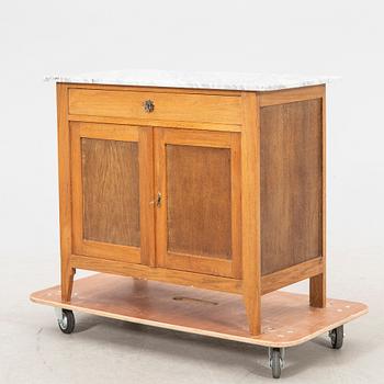 An early 1900s oak and marble cabinet.