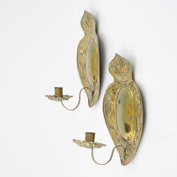 A pair of Baroque repoussé brass one-light sconces, first part of the 18th Century.