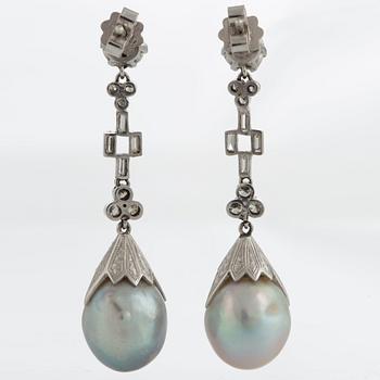 Ett par örhängen med droppformade pärlor i etui från Cartier.