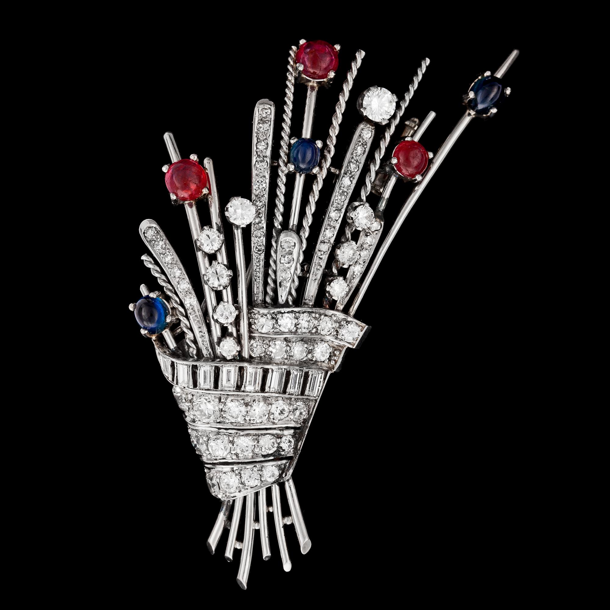 BROSCH, blå cabochonslipade safirer, rubiner med briljant- och baguetteslipade diamanter, tot. ca 3 ct. 1930-tal.