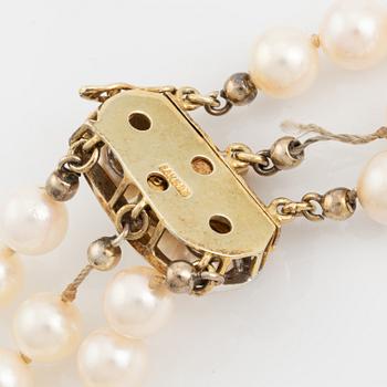 Three-row pearl necklace, cultured pearls, gold clasp with octagonal cut diamonds.