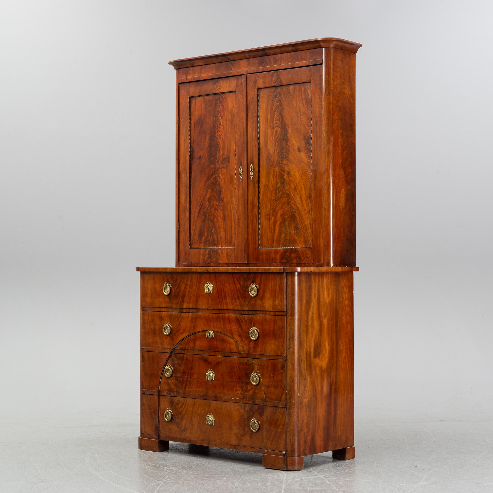 A mahogany veneered Empire cupboard, first half of the 19th century.