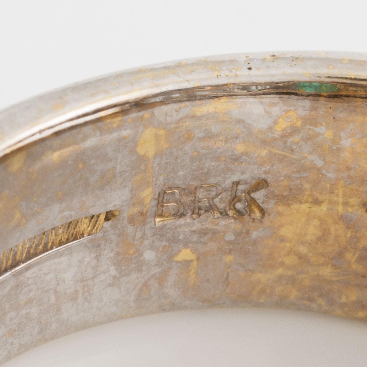 A ring in 18K gold set with a faceted emerald and baguette-cut diamonds.