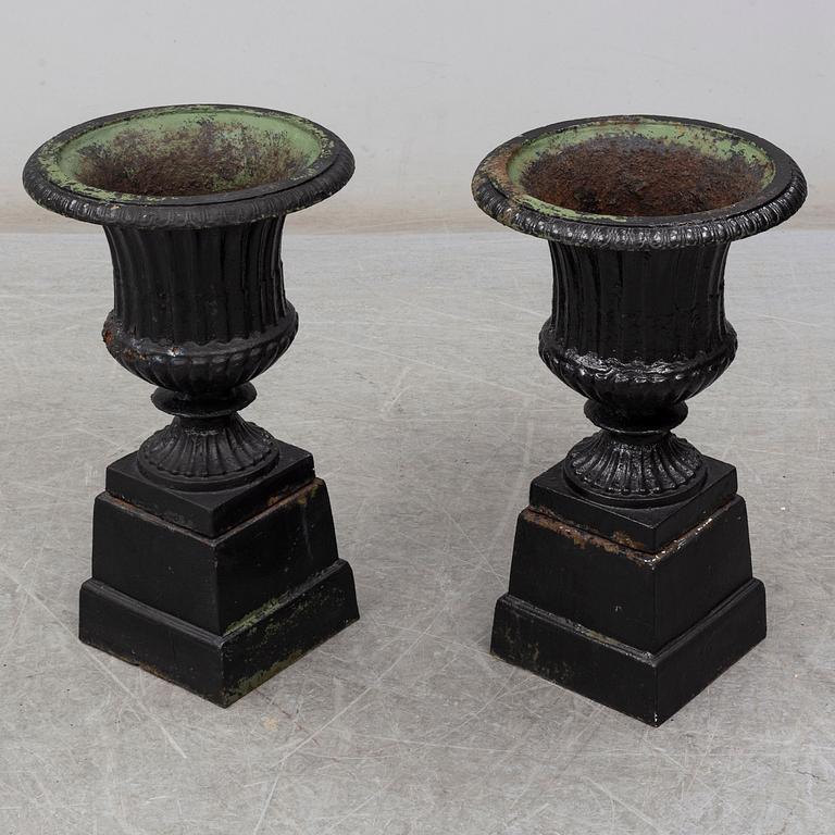 A pair of 20th century cast iron urns.