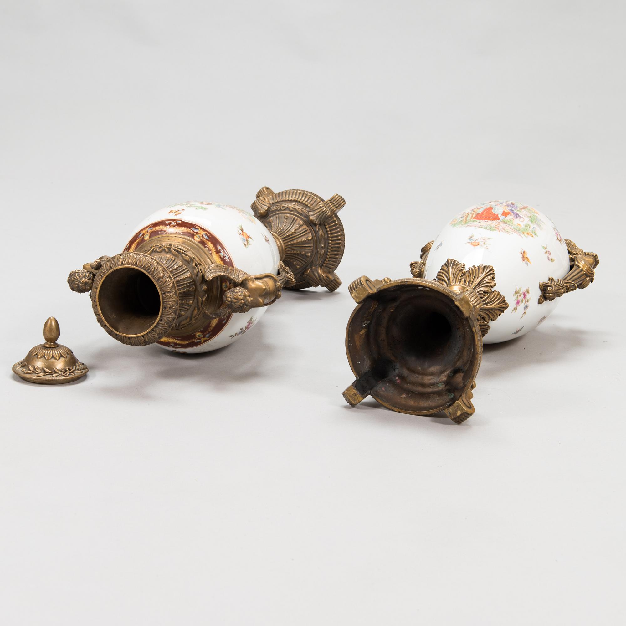 A pair of urns with lids, in bronze and porcelain, 20th century.