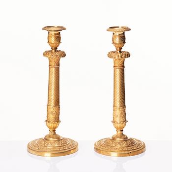 A pair of French gilded Empire candlesticks, early 19th century.