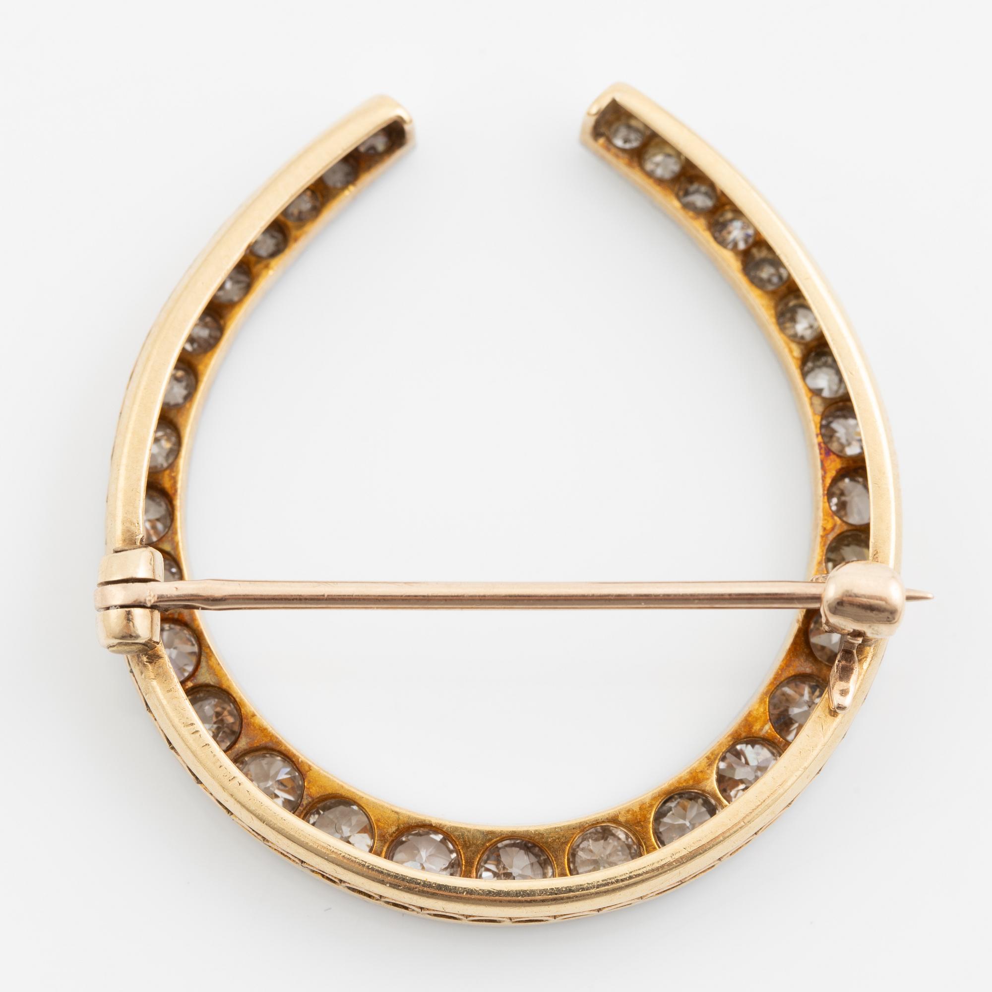 Brosch i form av hästsko, 14K och platina med gammalslipade diamanter totalt ca 1.80 ct, omkring sekelskiftet 1900.