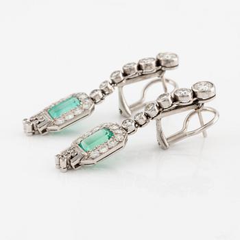 A pair of earrings in 18K white gold set with faceted emeralds and round brilliant- and eight-cut diamonds.