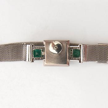 Gübelin bracelet watch in 950 platinum with round brilliant-cut and single-cut diamonds as well as step-cut emeralds.