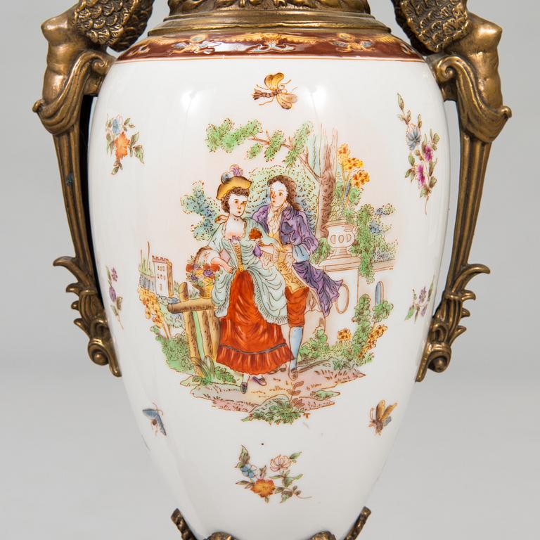 A pair of urns with lids, in bronze and porcelain, 20th century.