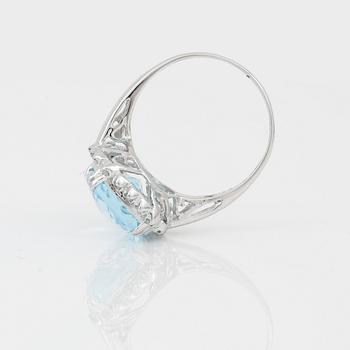 RING, 18K vitguld med chequerslipad blå topas, ca 5,23 ct, diamanter tot ca 0,20 ct. Vikt ca 4,17 g.