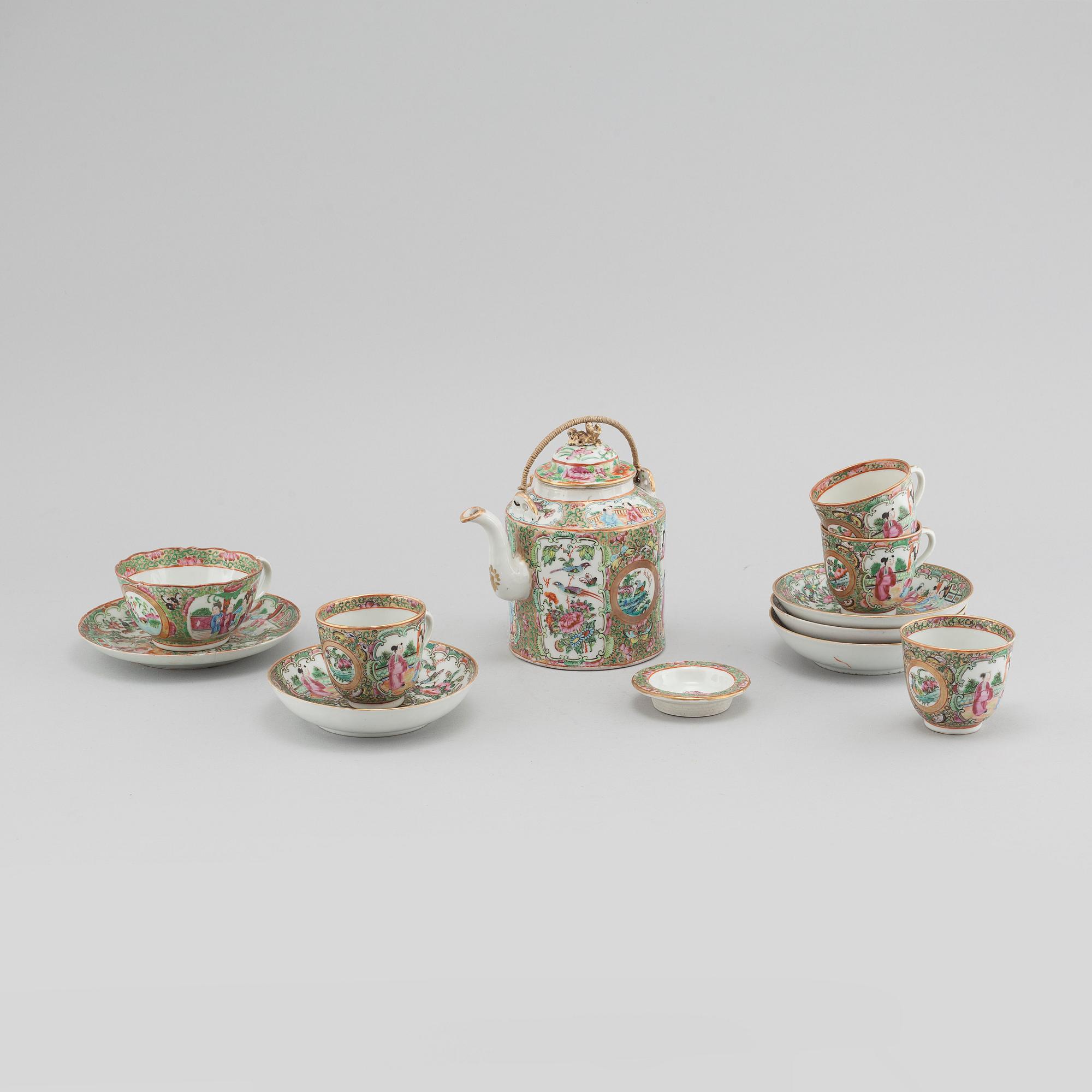 A chinese porcelain tea pot and four plus one cup, around the year 1900.
