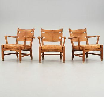 SCANDINAVIAN MODERN, a set of three mid 20th century mahogany and brown leather easy chairs.