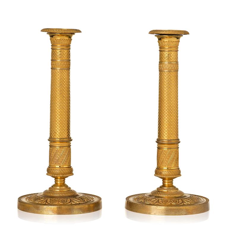 A pair of French Empire ormolu candlesticks, early 19th century.