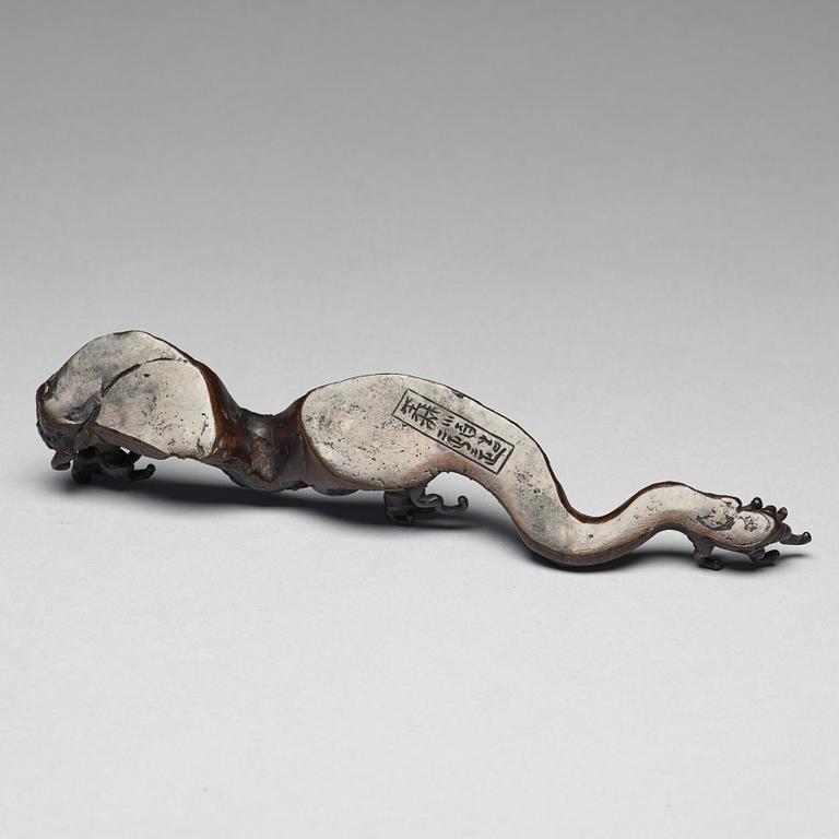 A bronze brush rest in the shape of a wave, Qing dynasty (1644-1912).