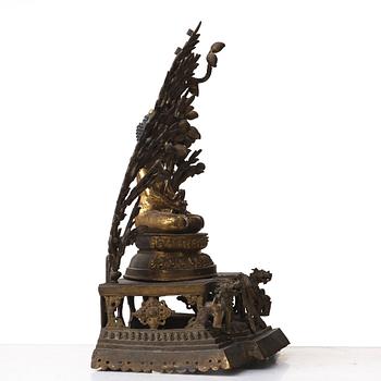 A large Nepalese gilt bronze buddha on a throne with mandorla, 18/19th Century.