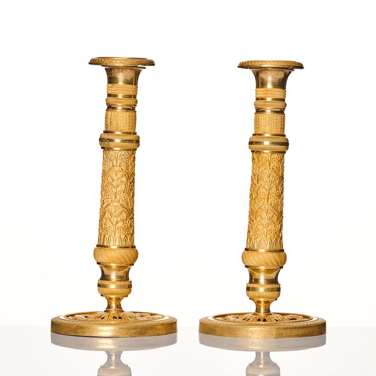 A pair of French gilded Empire candlesticks, early 19th century.