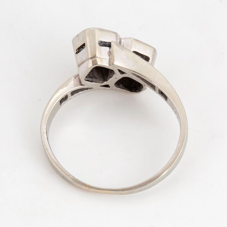 Brilliant-cut diamond crossover ring.