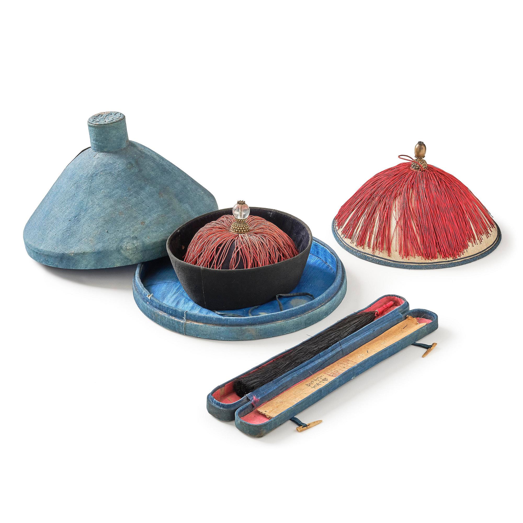 Two boxes with a mandarin's summer hat and black satin autumn hat and feather with six mandarin hat insignias.