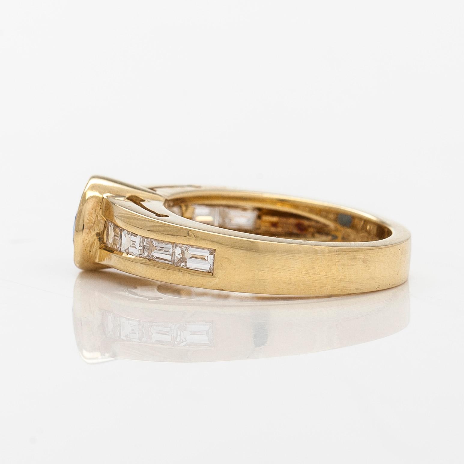 An 18K gold ring with an oval sapphire and baguette-cut diamonds. Finnish hallmarks, year 2000.