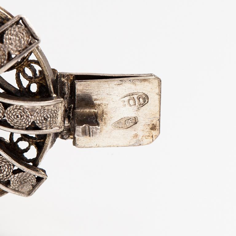 A silver and sea shell cameo bracelet.
