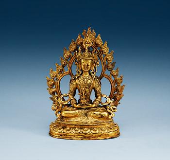 A gilt bronze seated figure of Amitayus, with separately cast nimbus, Qing dynasty (1644-1911).