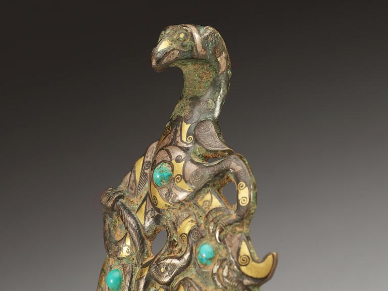An archaistic silver and gilt bronze garment hook.