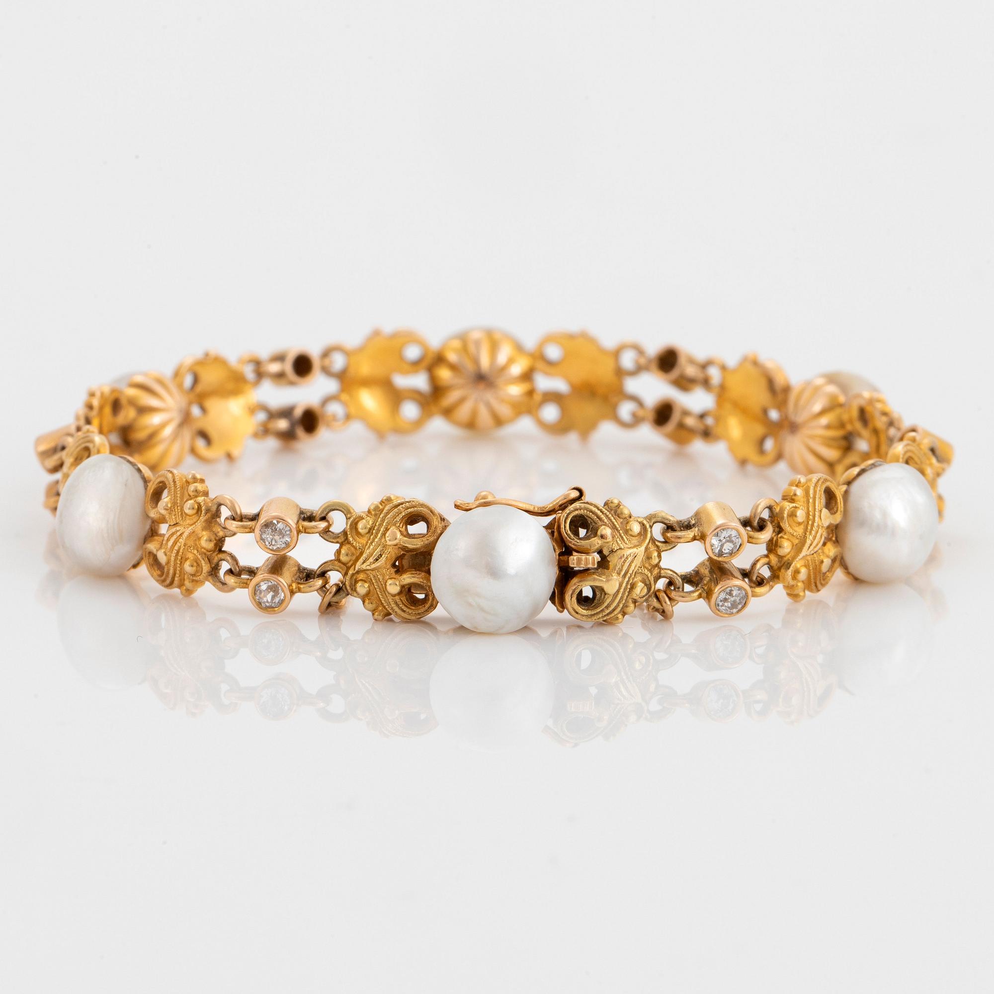 A 14K gold bracelet set with pearls, possibly natural, and old-cut diamonds.