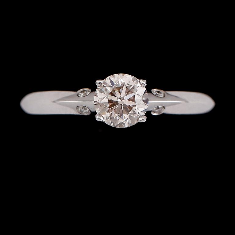 RING, 18 k vitguld, solitär briljantslipad diamant ca 0.71 ct, 4 mindre briljantslipade diamanter tot ca 0.03 ct.
