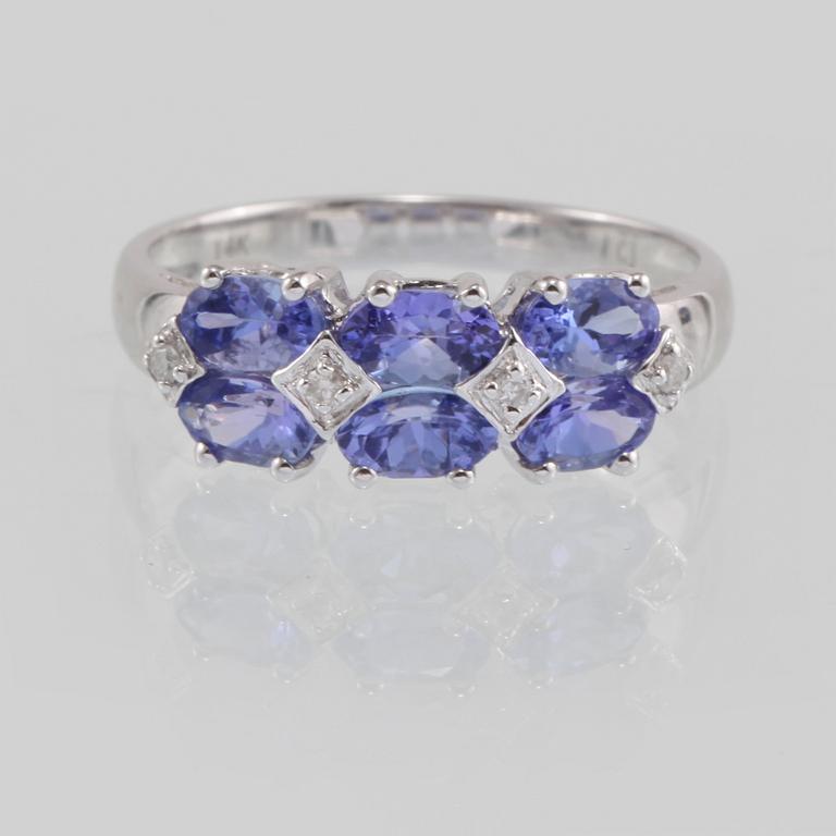 RING, 14K vitguld med 4 briljantslipade diamanter samt 6 fasettslipade tanzaniter. Vikt 2,4 gram.