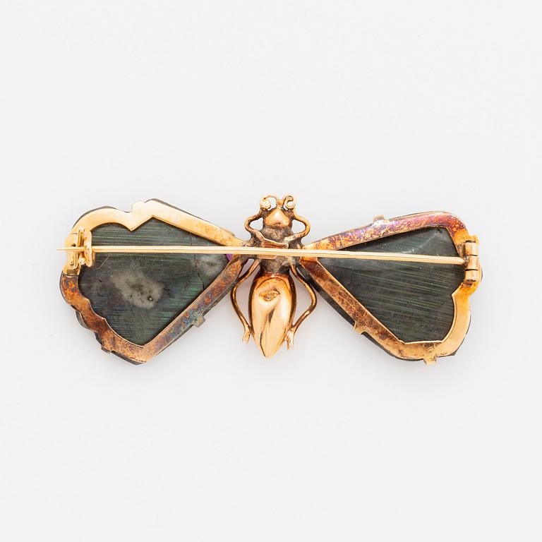 A butterfly brooch in 14K gold set with labradorite, rubies, rose-cut diamonds and garnets.