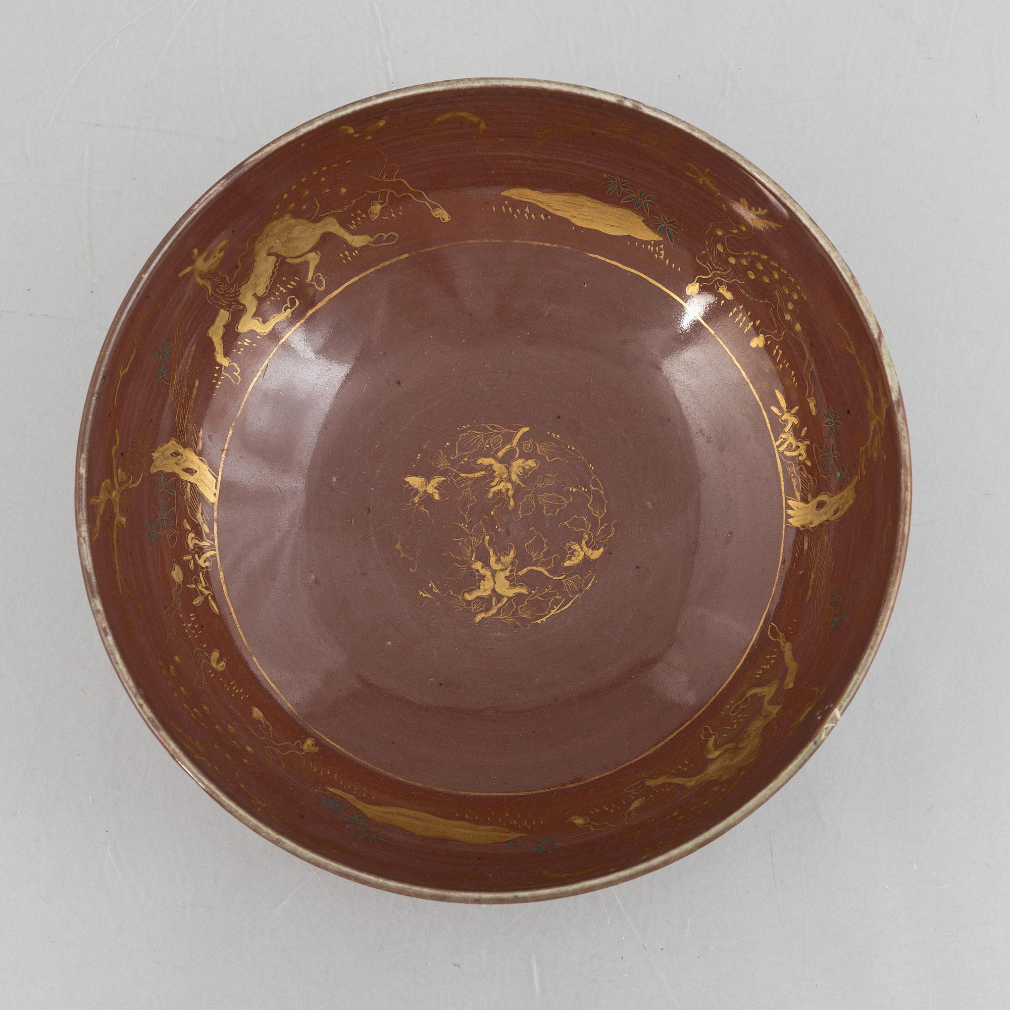 A brown glazed bowl with gilded decoration of animals and antiques, Qing dynasty, 19th century.