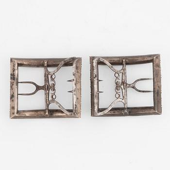 A pair of shoe buckles in white metal with green paste stones.