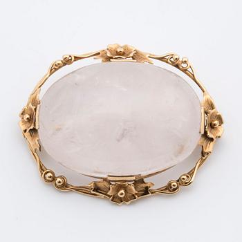 A cabochon-cut rose quartz brooch.