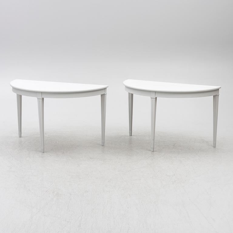 A pair of crescent shaped tables, 20th century.