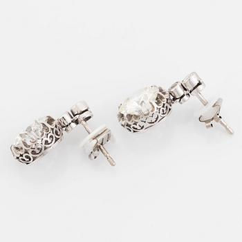A pair of platinum earrings set with round brilliant- and old-cut diamonds.