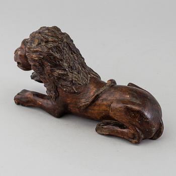 A 17TH CENTURY CARVED WOOD FIGURE OF A LION.