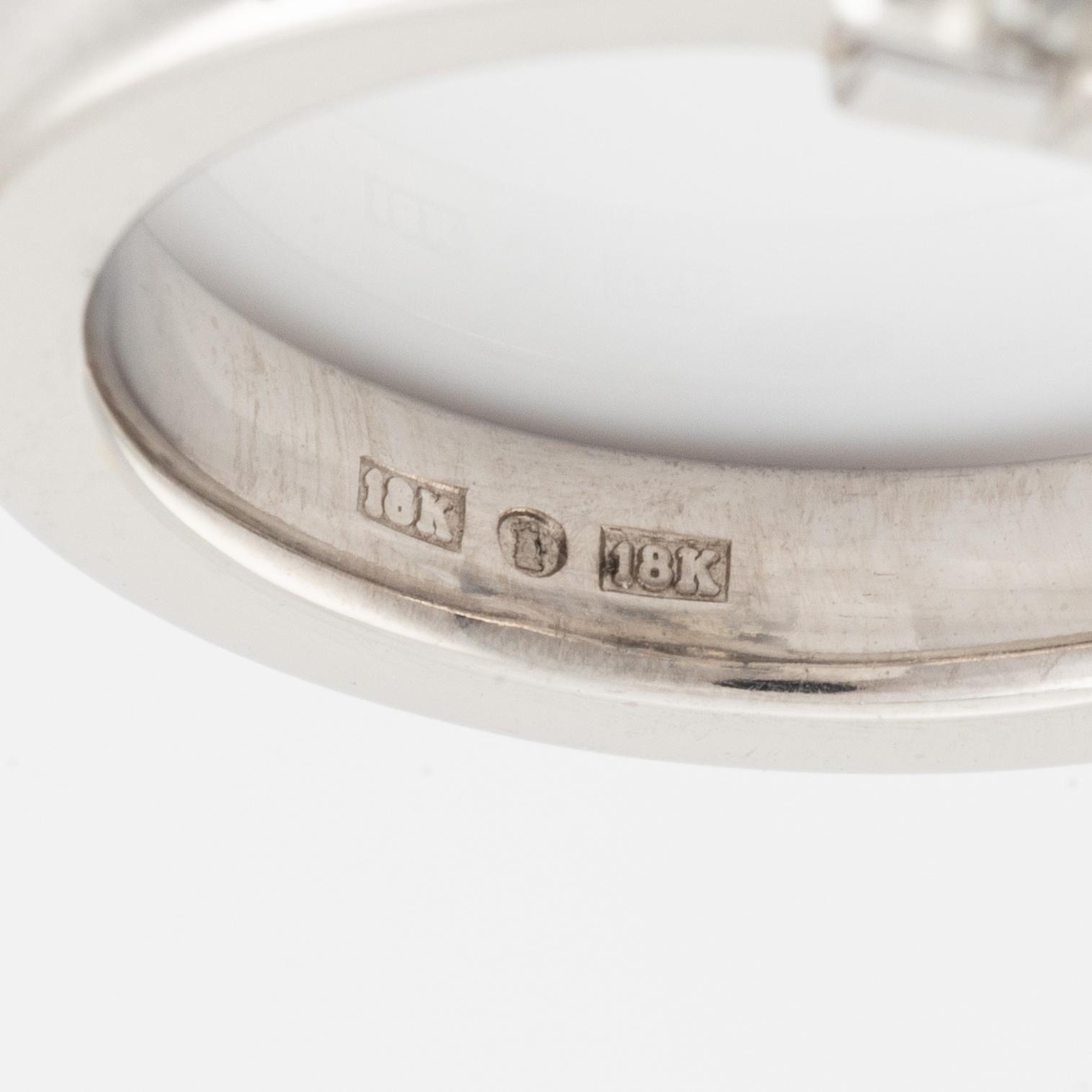 An 18K white gold ring set with a round brilliant-cut diamond.