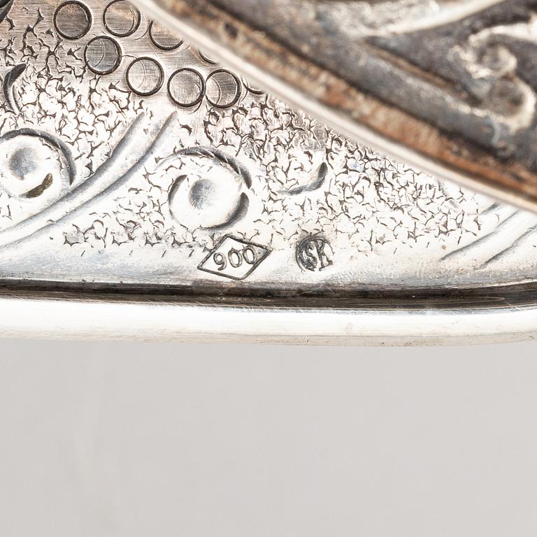 A silver bottle holder with wheels, 20th Century.