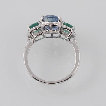 RING, 18K vitguld med fasettslipad kyanit 3.49 ct, 2 smaragder 1.23 ct och briljantslipade diamanter 0.33 ct. Vikt 3 g.