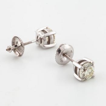 A pair of brilliant cut diamond earrings.