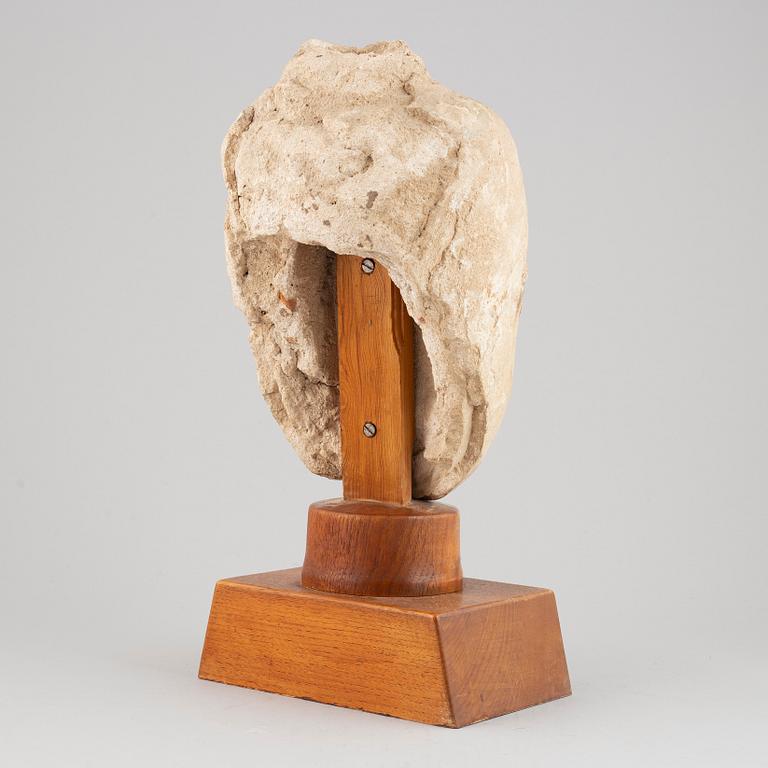 A South East Asian stone mass sculpture of a head, presumably modern manufacturing.