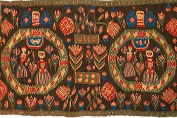 A carriage cushion, "the Annunciation", tapestry weave, ca 103 x 51 cm, south western Scania (Sweden), 1833.