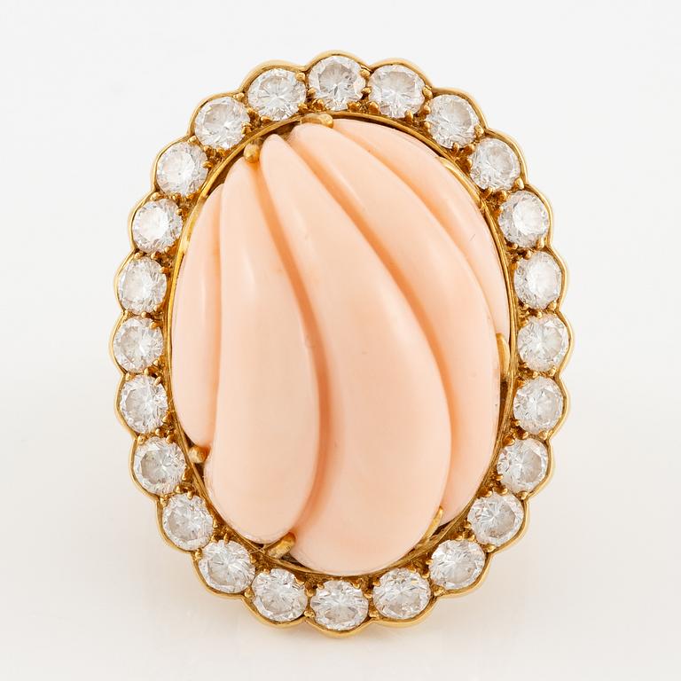 An 18K gold and coral Cartier ring set with round brilliant-cut diamonds.