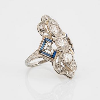 An 18K white gold ring set with old-cut diamonds and faceted sapphires, probably synthetic.