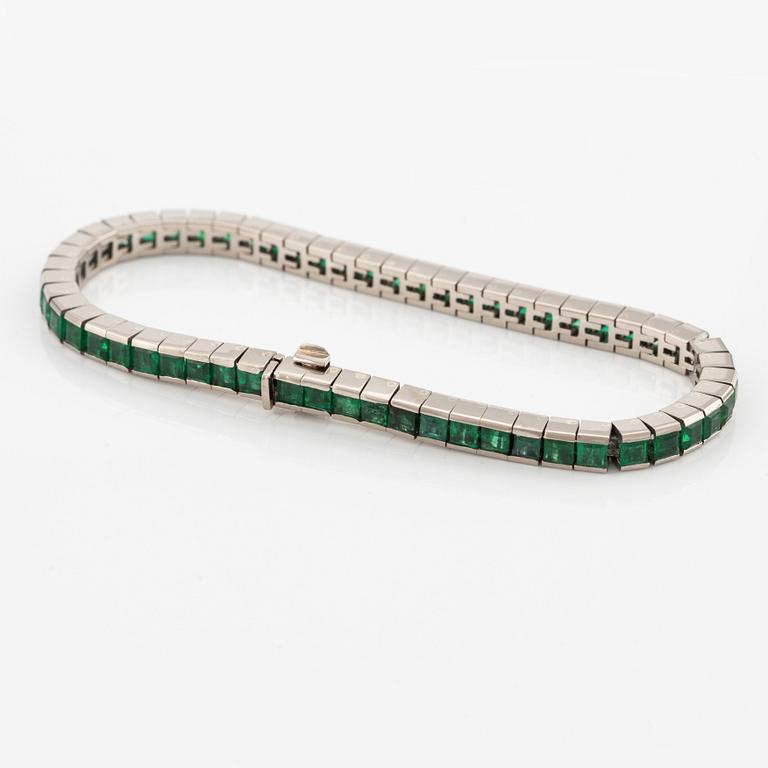 An 18K white gold bracelet with step-cut emeralds.