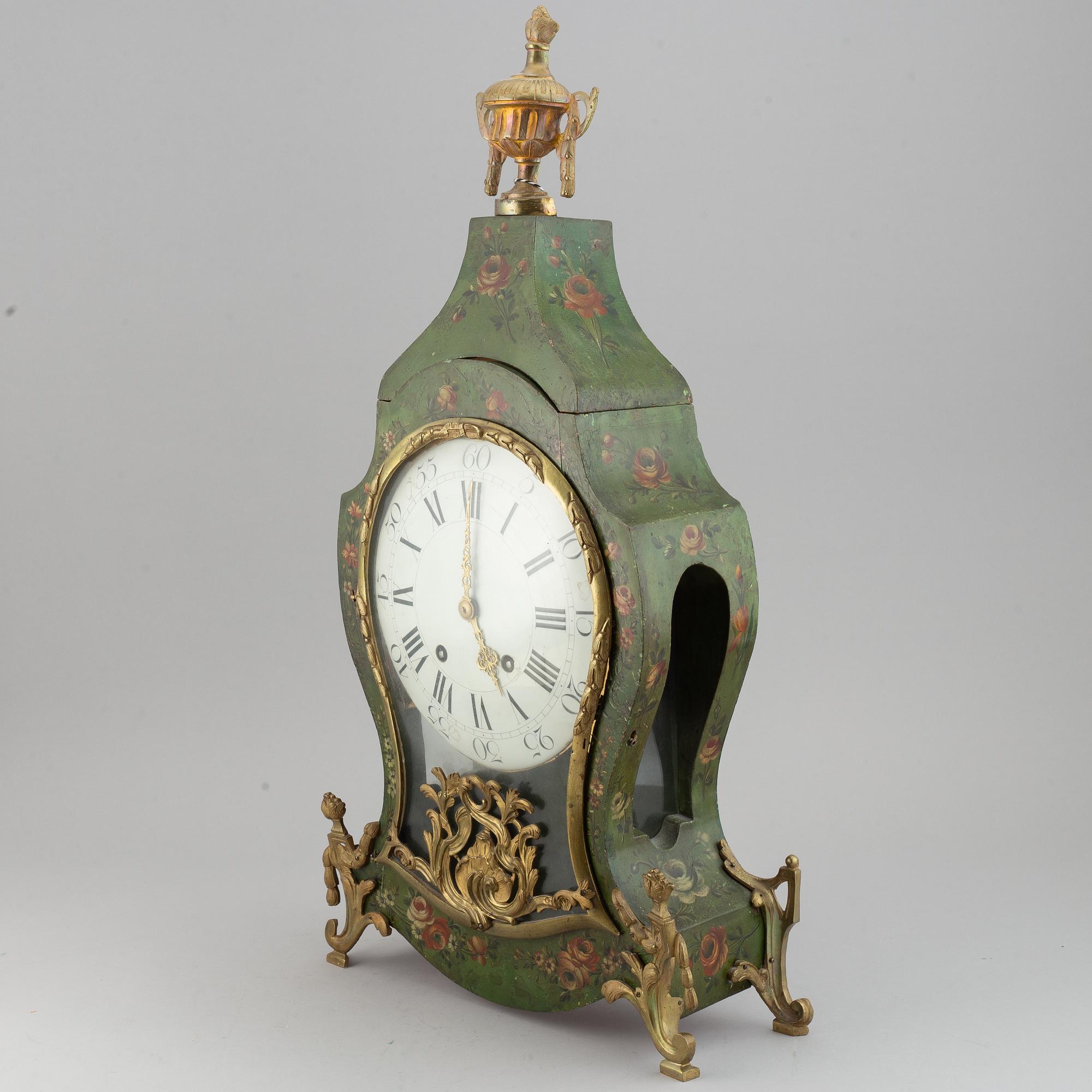 A rokoko style table clock. Pendulum and two keys. 19/20th century.