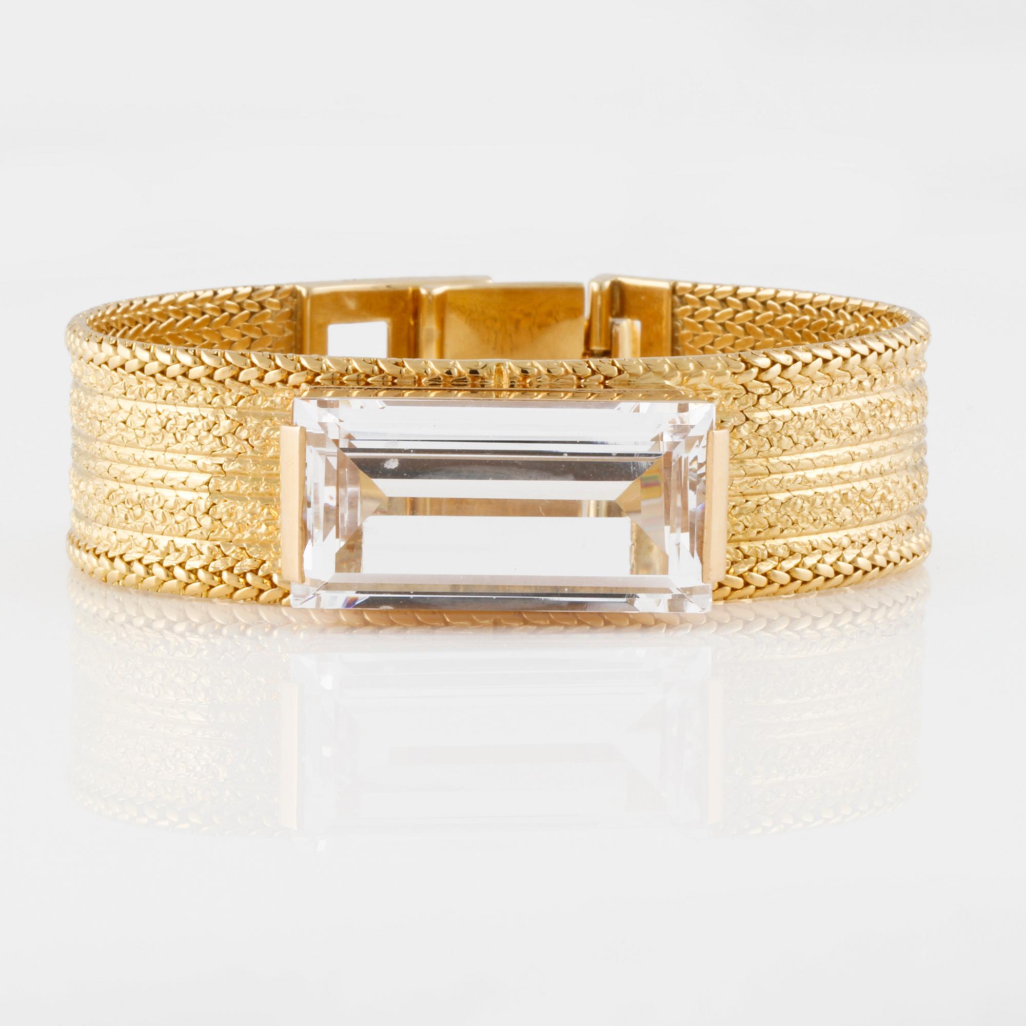 ARMLÄNK, 18K guld med fasettslipad vit syntetisk spinell, importstämplad. Vikt 68,9 gram.