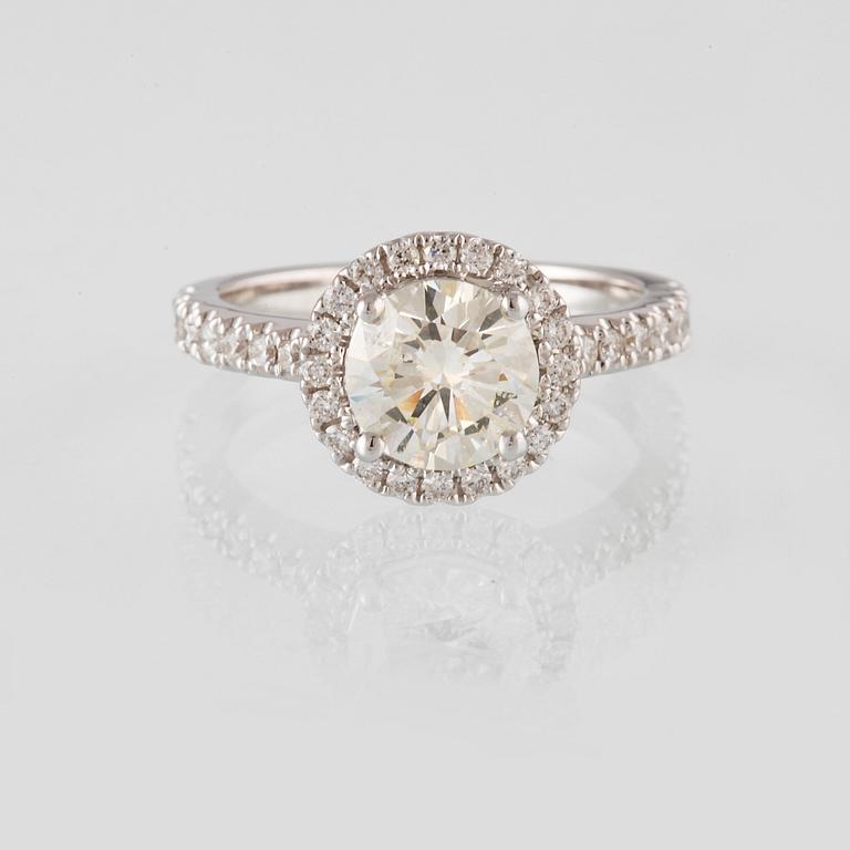 RING, 18K vitguld med en briljantslipad diamant 1.44 ct samt små briljantslipade diamanter 0.50 ct. Vikt 4,6 gram.