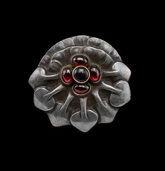 A BROOCH, 826 silver, garnets. Georg Jensen Copenhagen 1909-14.  Ø 4,2 cm.